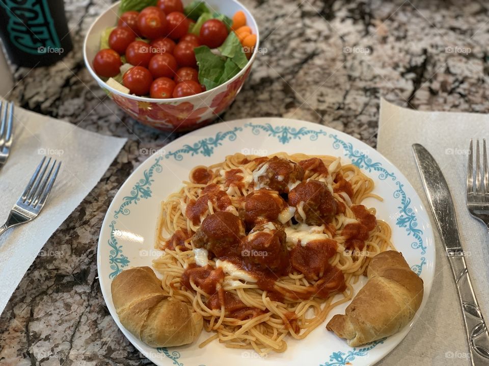 Meatball dinner with salad and croissants