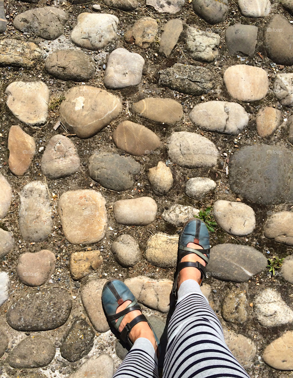 Looking down on my feet on cobbler stones