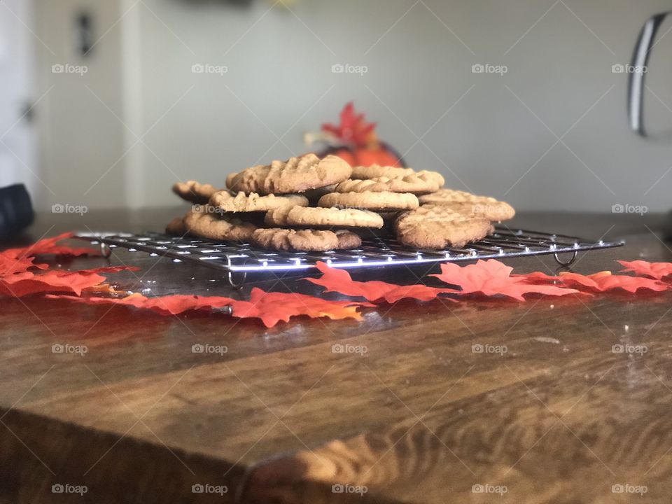 Golden Brown Peanut Butter Cookies on a Rack with Maple leaves on a table 