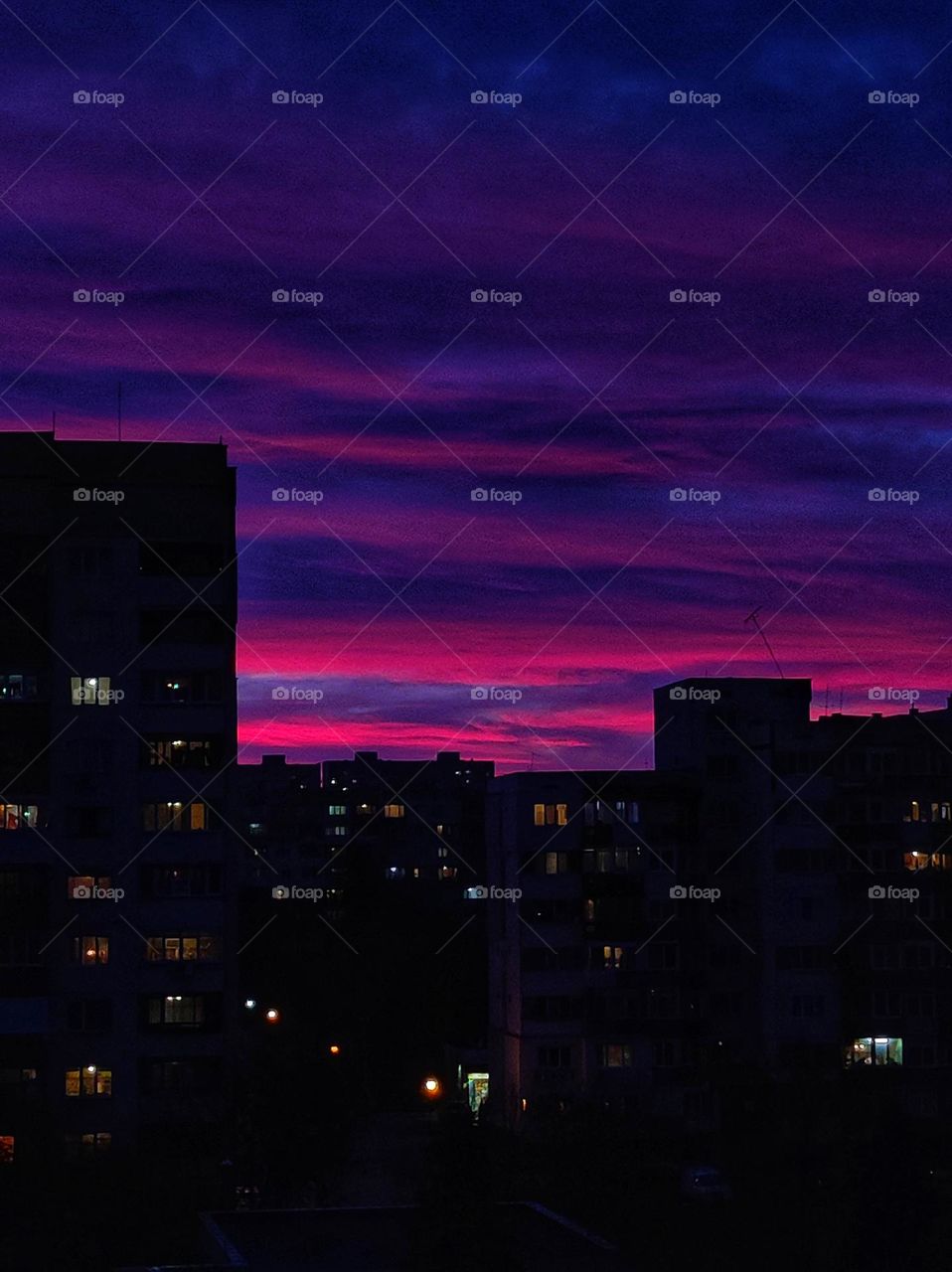 A picturesque scenery of the sunset clouds in amazing colours like orange, red, purple and pink with the apartment buildings beneath in the capital of Bulgaria