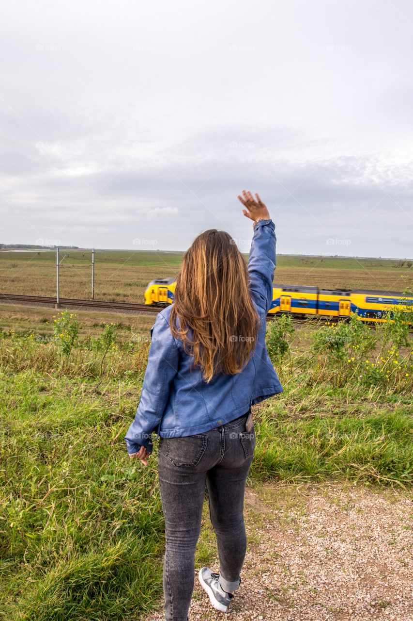 Girl waving at the passing train