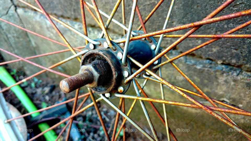 Velho cubo, eixo de roda de bike, com raiamentos enferrujados.