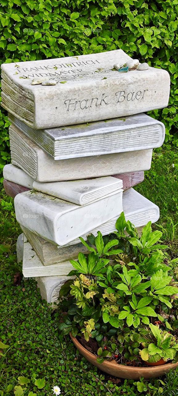 “Frank Baer” who lies here at the “Nordfriedhof”, the north cemetery in “Munich”, Germany must have loved books as well as art. His gravestone is a stone sculpture of a stack of books. One of them has his name inscribed. 2023. Hypnotic Productions