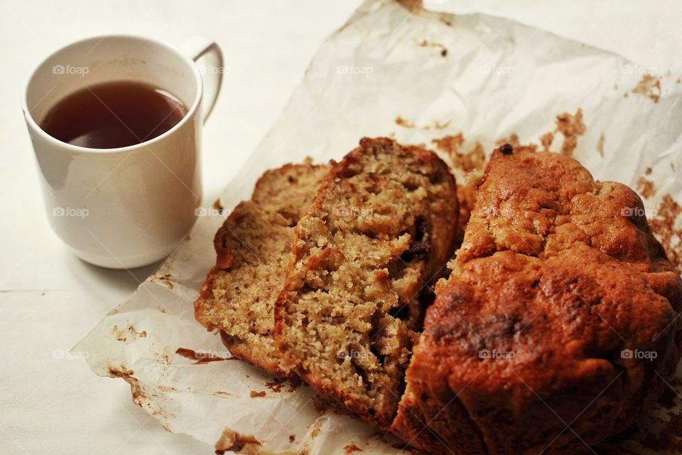 Sliced ​​banana pie with black tea in a porcelain mug