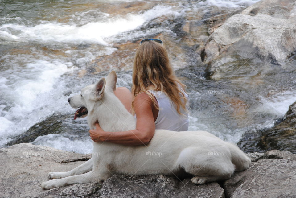 Lady Sits Beside River with Her Dog, A White German Shepherd