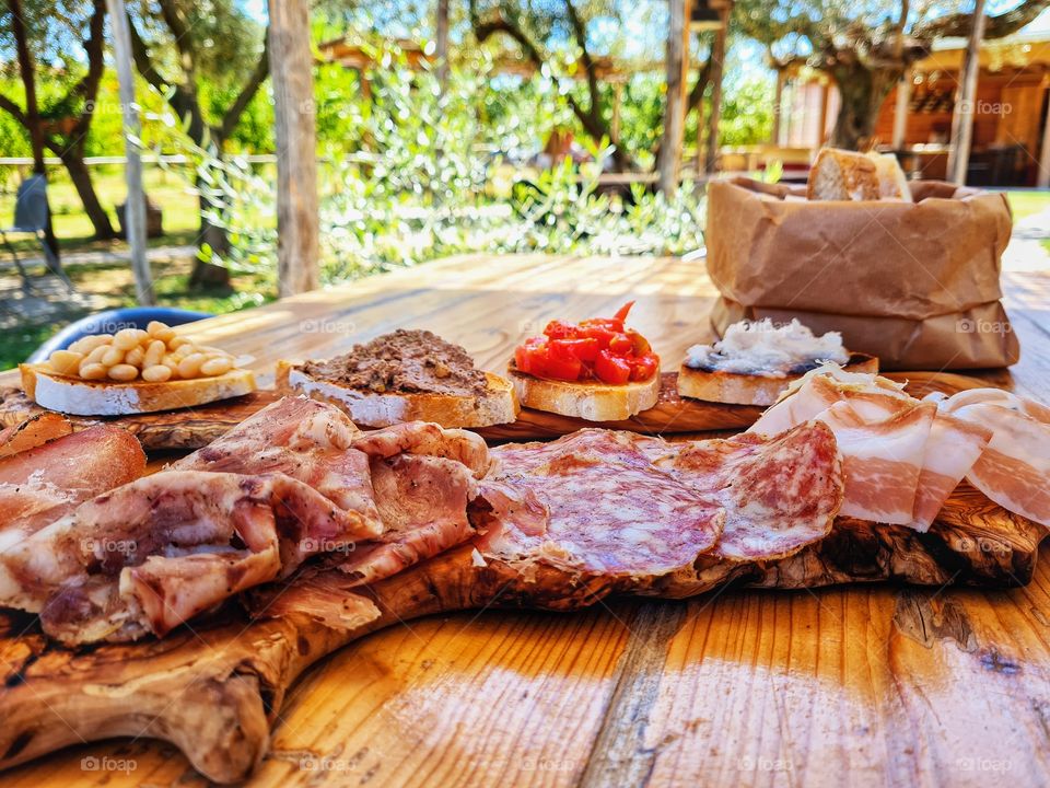 outdoor table with ham platter and assorted bruschetta