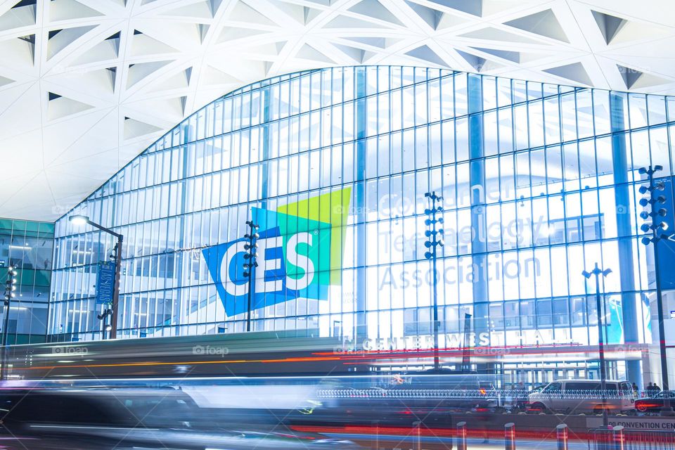 Las Vegas, NV, USA 1-6-2023: Exterior of Convention Center West Hall during CES2023. Logo of CES on glass wall. Light trails from car headlights of traffic passing by. Captured in long exposure.