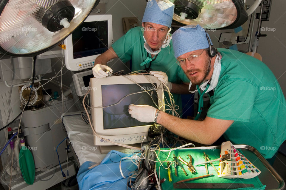 Two men operate on a computer in the emergency room at a hospital