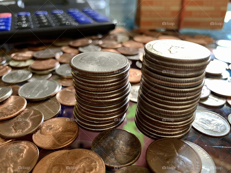 Scattered us coins in the table including pennies, quarters, dimes, nikle. Segregation of quarters.