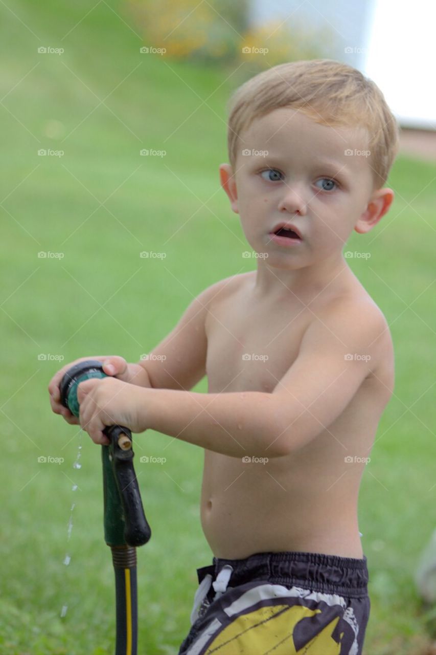 Close-up of boy holding pipe hose