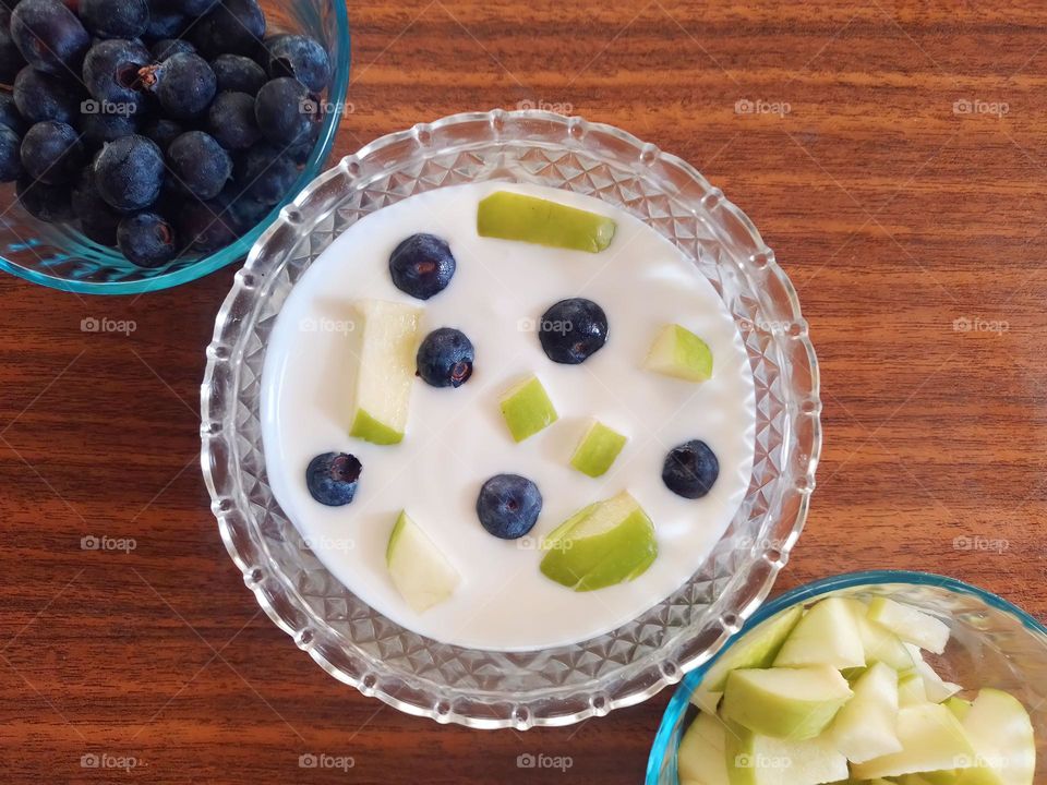 blueberries, green apple and greek yogurt on the table