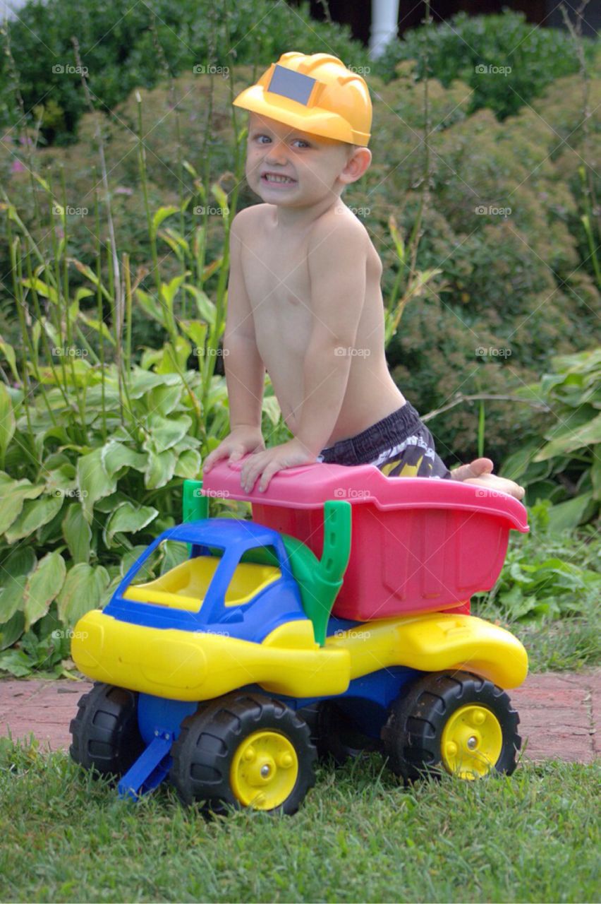 Boy playing with his toy car in garden