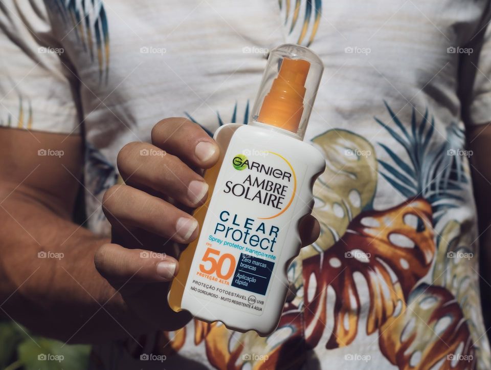 Ambre Solaris factor 50 held by a tanned man in a vintage Hawaiian shirt 