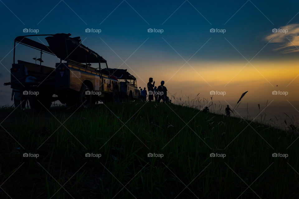 A group of traveler finally reach the peak of the hills at the right time before sunset, as expected