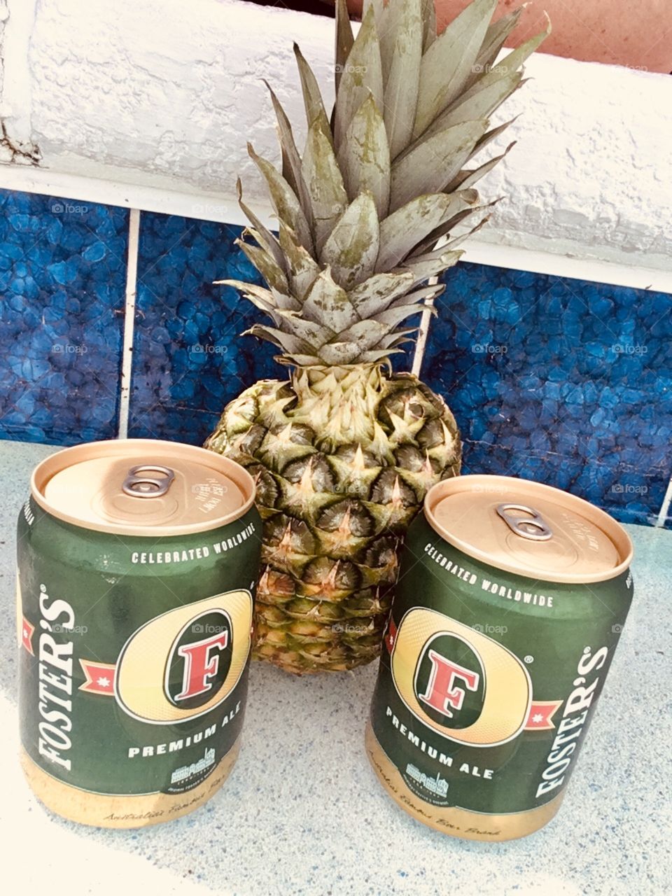 Fosters with a pineapple in a pool 🍍