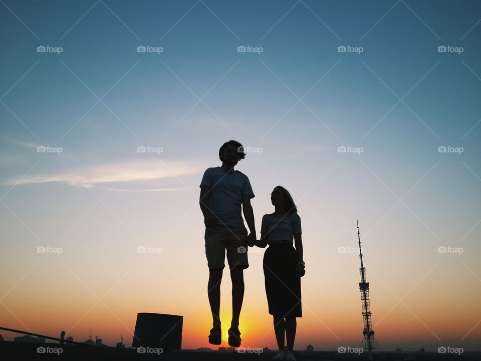love on Kiev roof. couple enjoying watching sunset on a roof of Kiev building