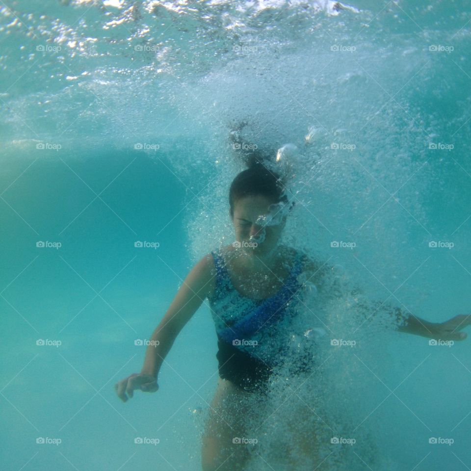 SPLASH!. Underwater view of a woman jumping into a pool