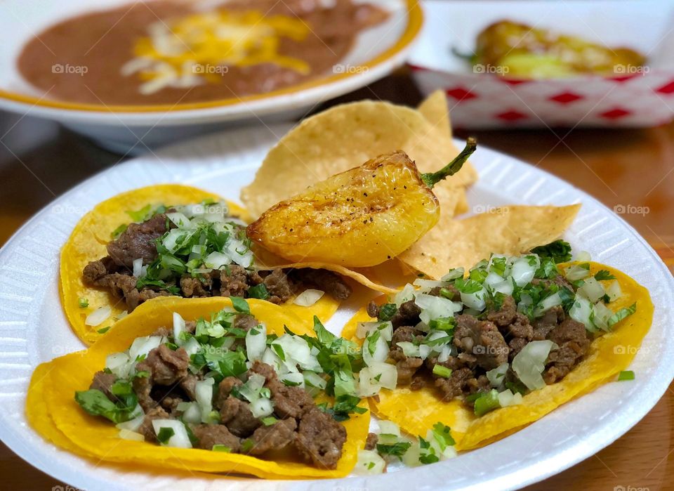 A delicious plate of carne asada tacos and yellow chili’s 