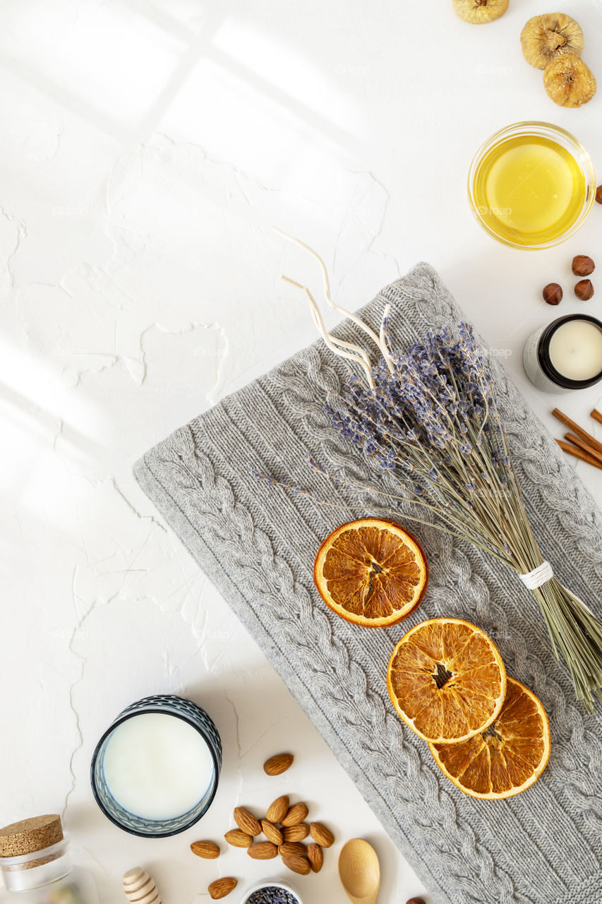 Relax concept. Cozy, comfortable, knitted blanket with a bouquet of lavender, a glass of milk and healthy snack for good sleep. Insomnia or depression treatment for sleepless nights. Top view