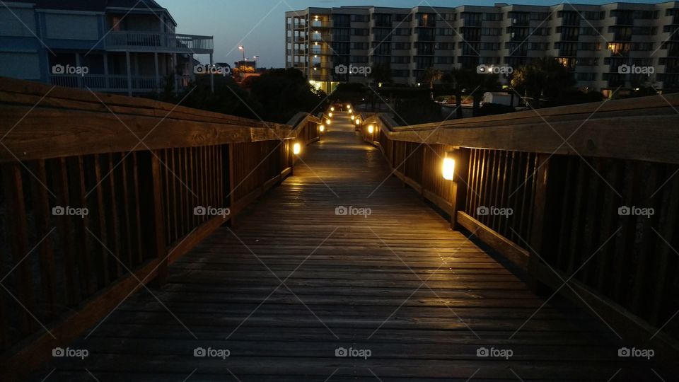 Lit boardwalk from the beach to the hotel