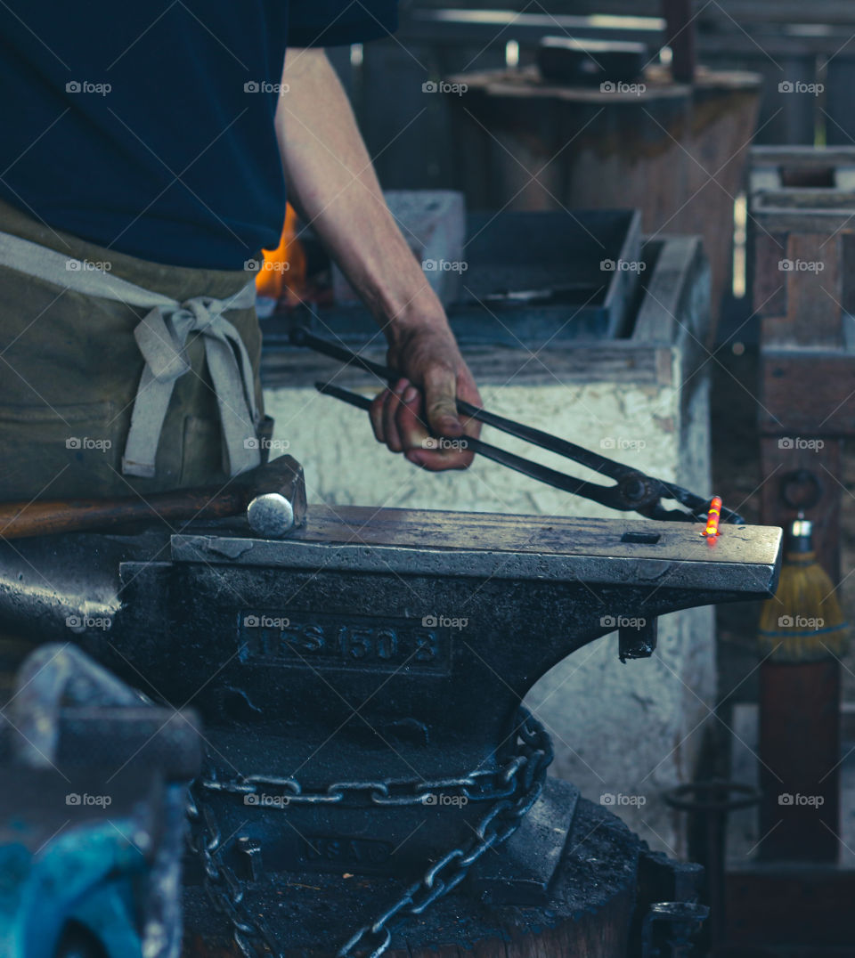 Scene of a local hand craftsmen with a heated metal in crowbar while metallic process 