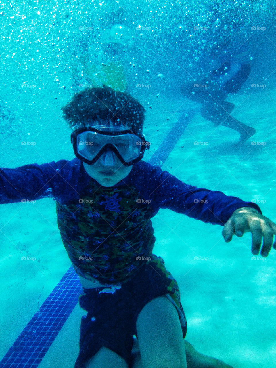 Boy with goggles swimming underwater