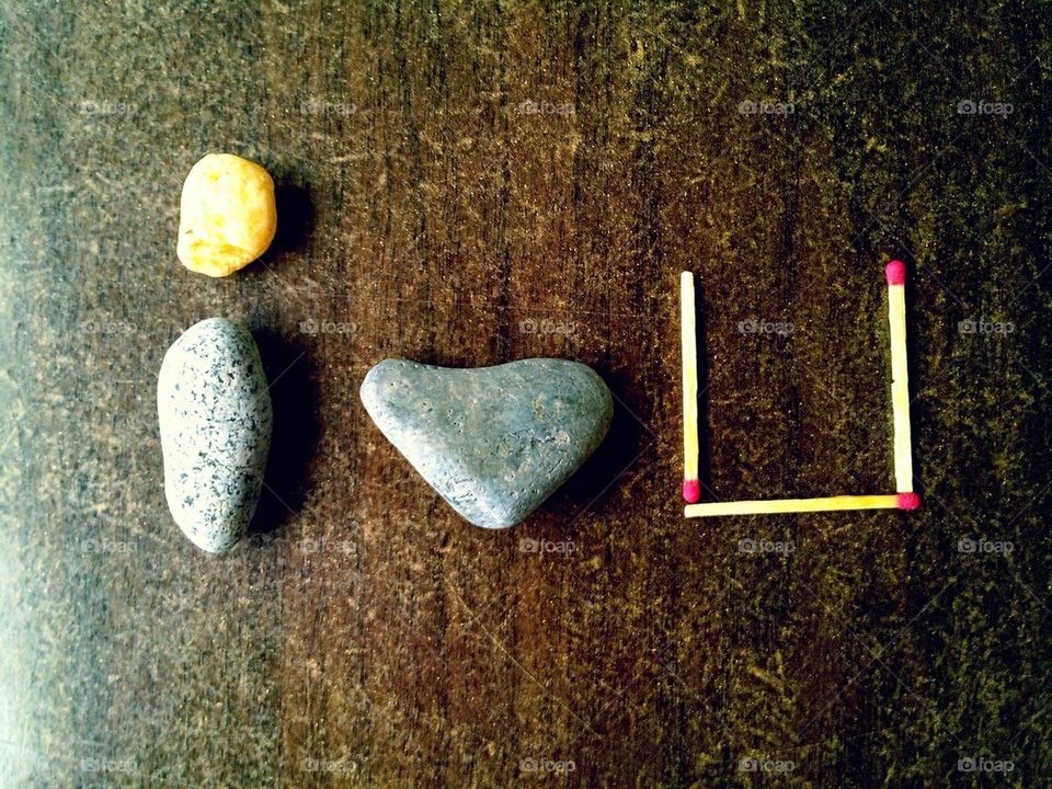 Stones, rocks and match sticks arranged to spell out the phrase I love
