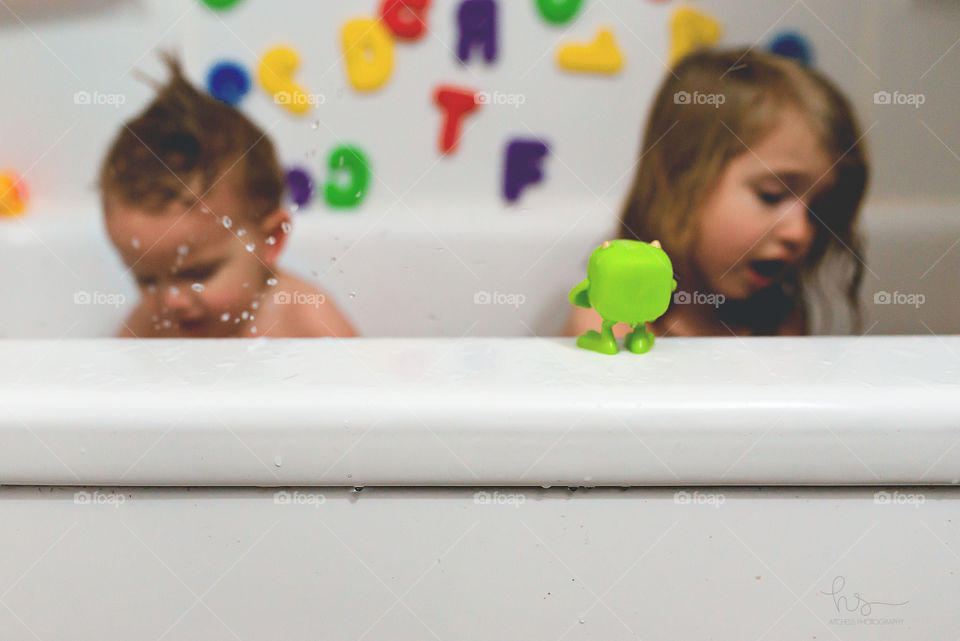 Kids in bathtub with toys 