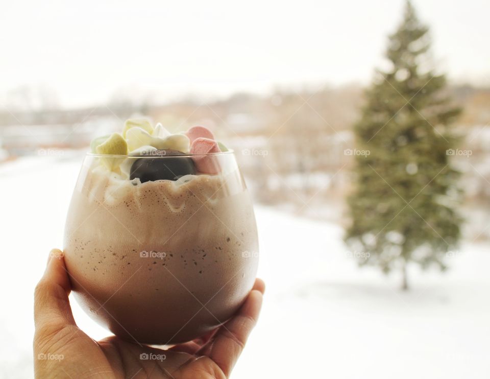enjoying chocolate drink with a view of snow