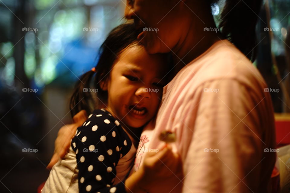 Small girl crying in mother arms 