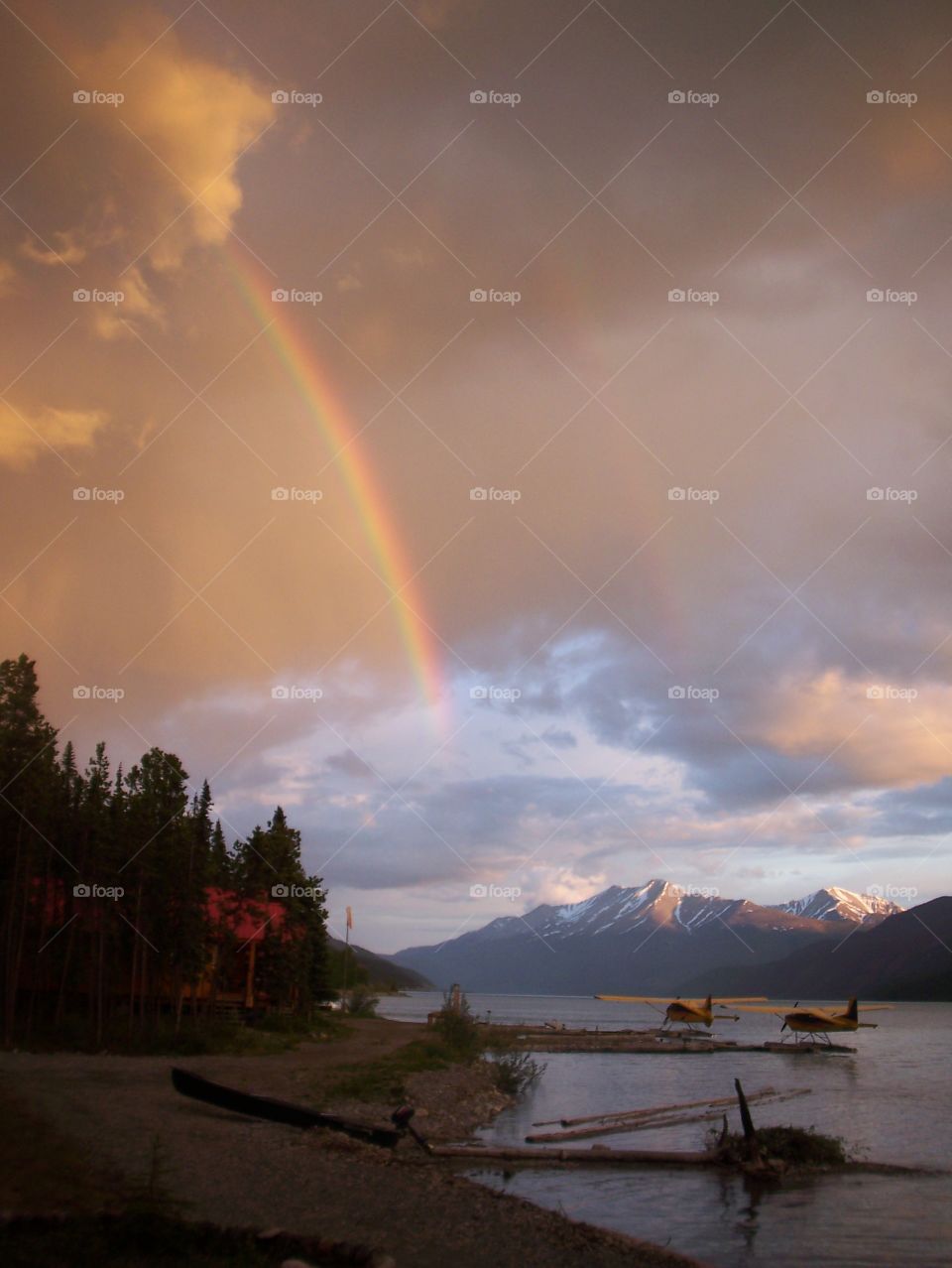 Seaplanes, mountains, a lake, and a rainbow 