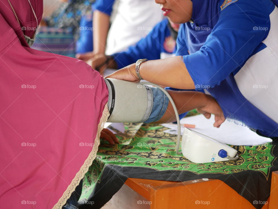 Tarakan/Indonesia-09172019: a family planning field officer was checking acceptor blood pressure before using contraceptives on September 17, 2019 in Tarakan, Indonesia
