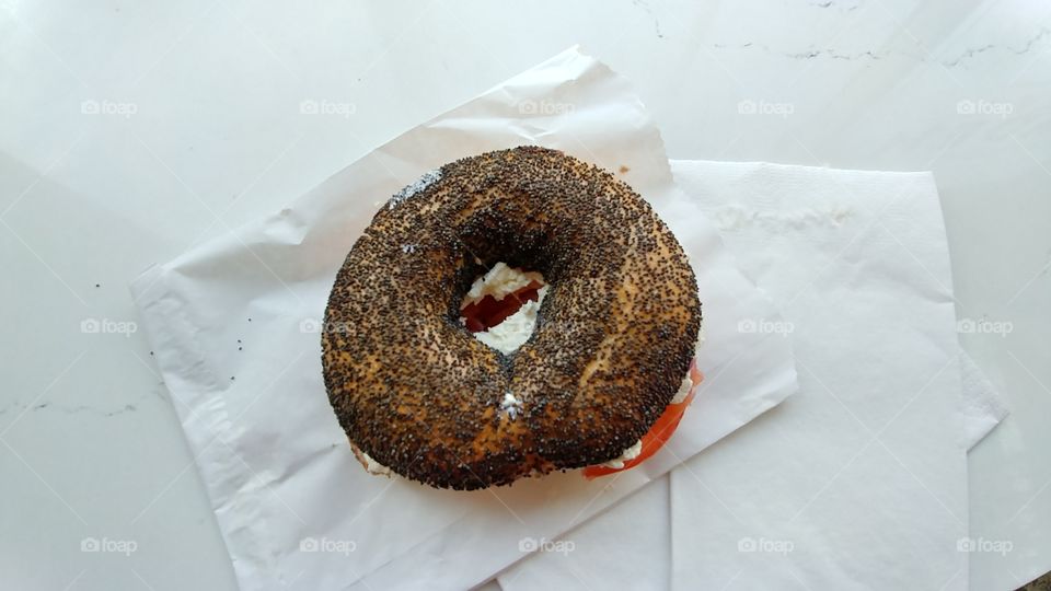 poppyseed lox bagel with cream cheese and tomato