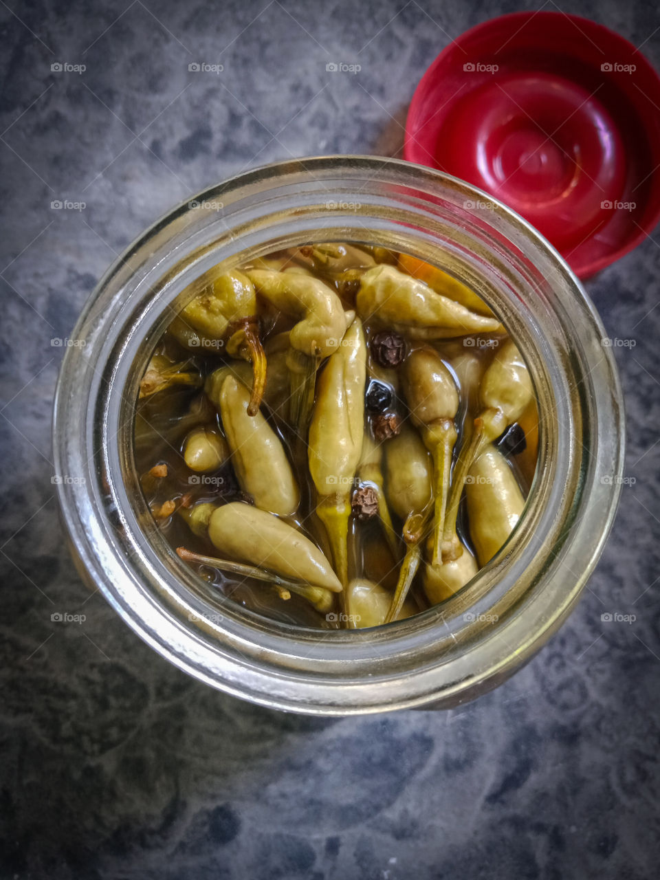 Bottle of homemade pickled chillies .