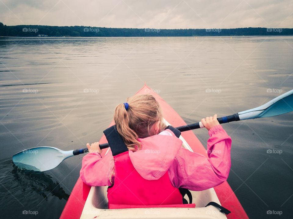 Little girl in a kayak on the lake