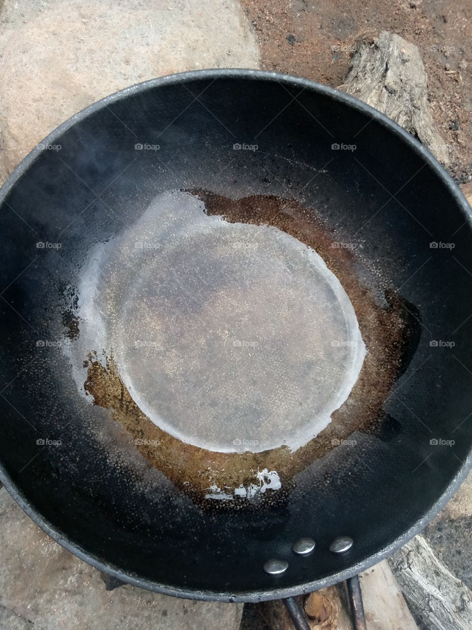 frying pan is set on fire, with groundnut oil poured into it waiting for the pan to hot, before pouring the eggs.