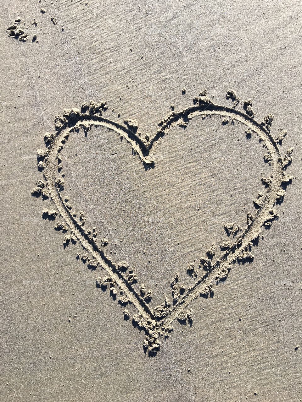 A bit of love carved into the sand, gone by the morning but captured forever by the lens.