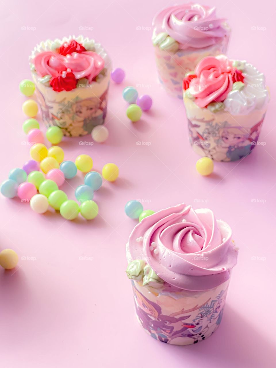 Pink and colourful cupcakes with pink background 