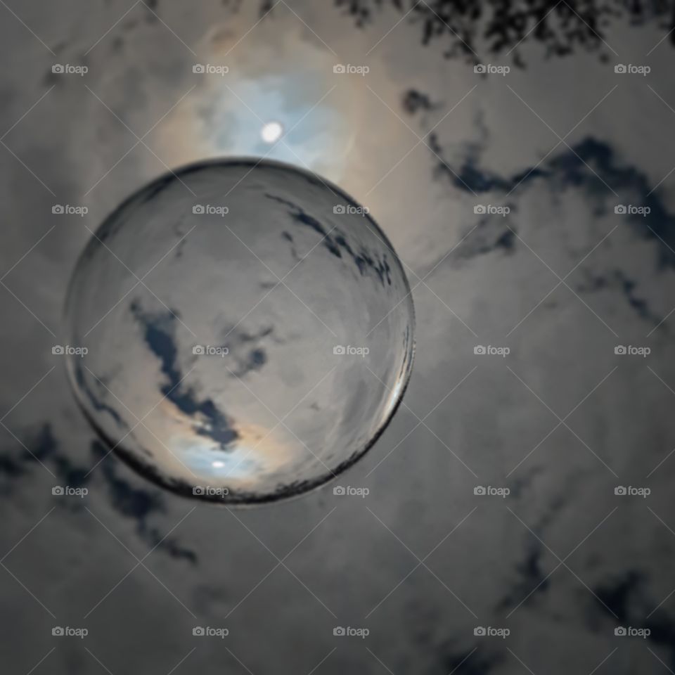 storm clouds and moon reflecting in globe