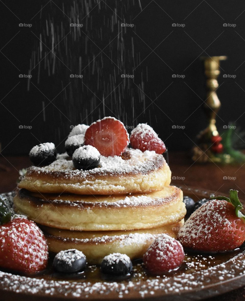 Christmas breakfast, pancakes with fruit and powdered sugar 