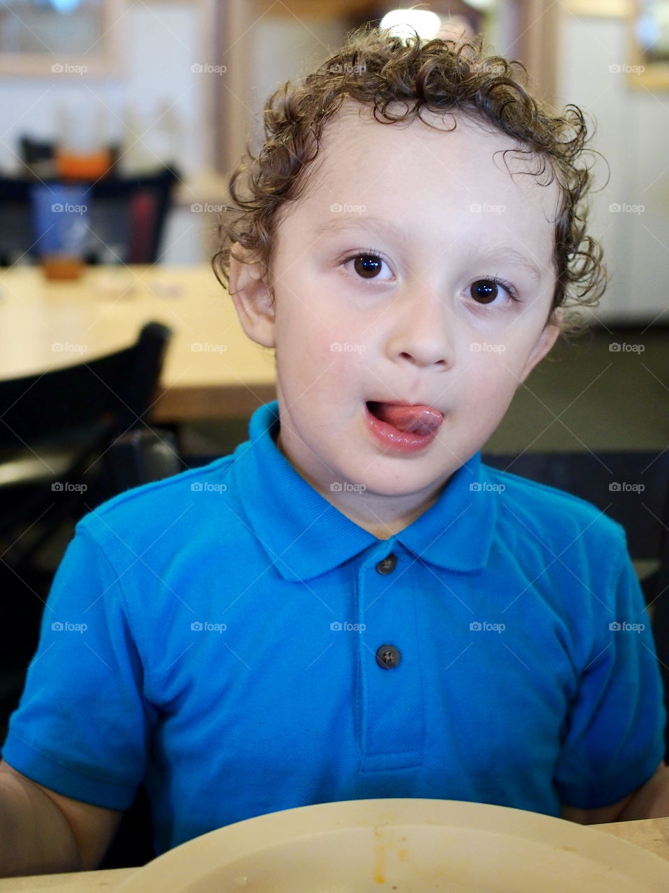 A little boy licks his lips after the joy of eating his favorite snack. 