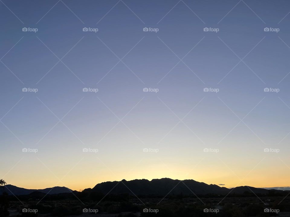 A colorful yellow sunset with mountains. 