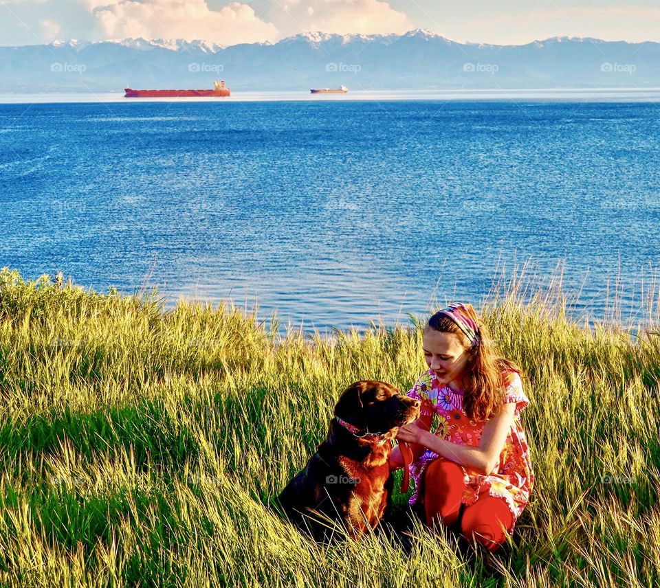 Girl and her dog take a scenic walk - ocean and mountains 