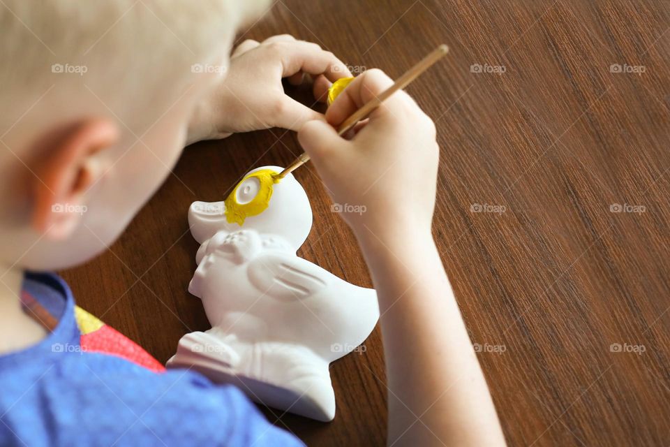 Child paints a duck figure 