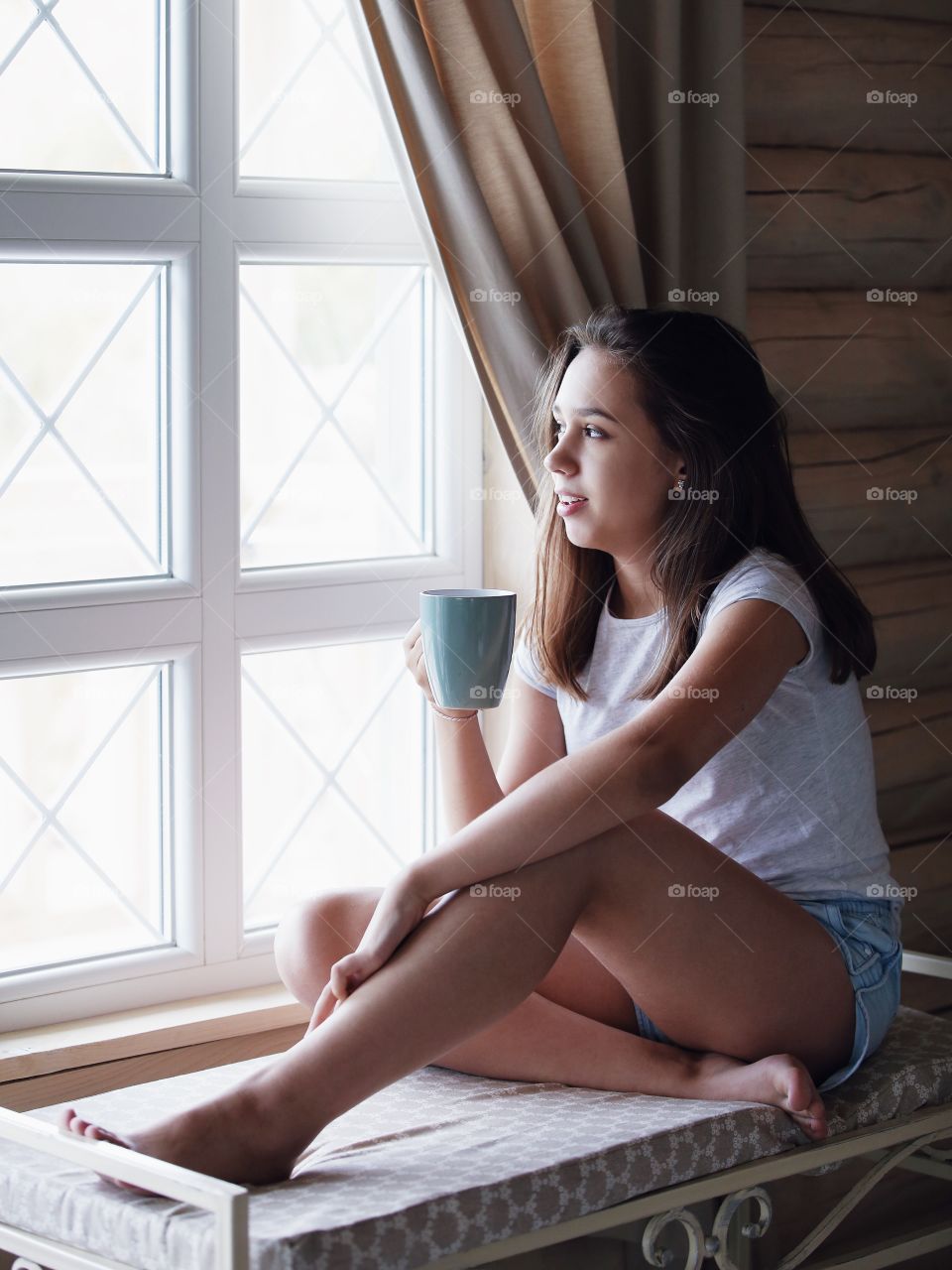 Girl drinking tea near the window in the morning