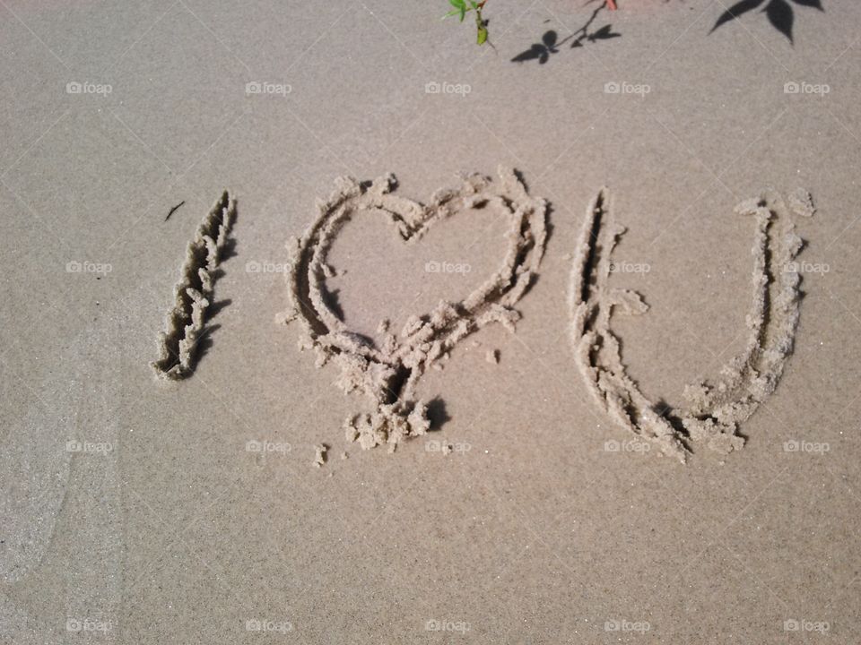 Writing in the Sand. I heart you, written in the sand on a beach