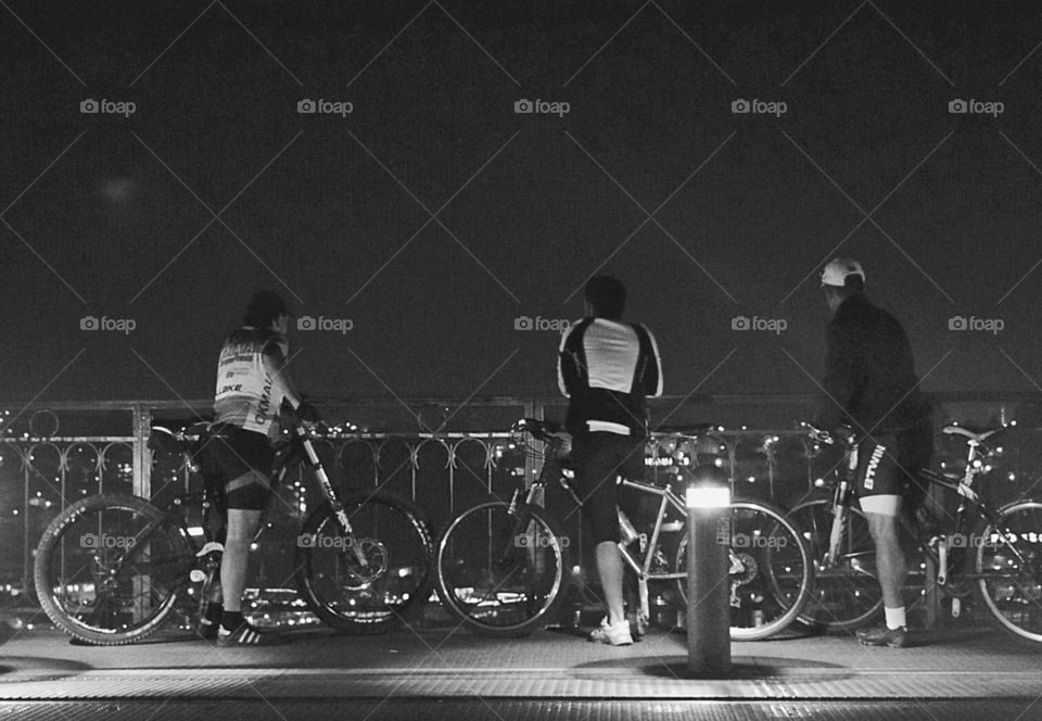 3 cyclists admiring the view from top of the bridge 