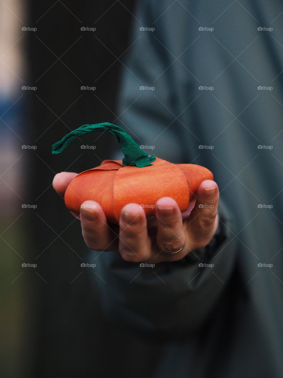 Unrecognisable woman holding in the hands handmade paper orange pumpkin 