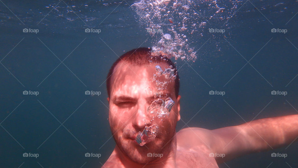 young man diving and swimming underwater