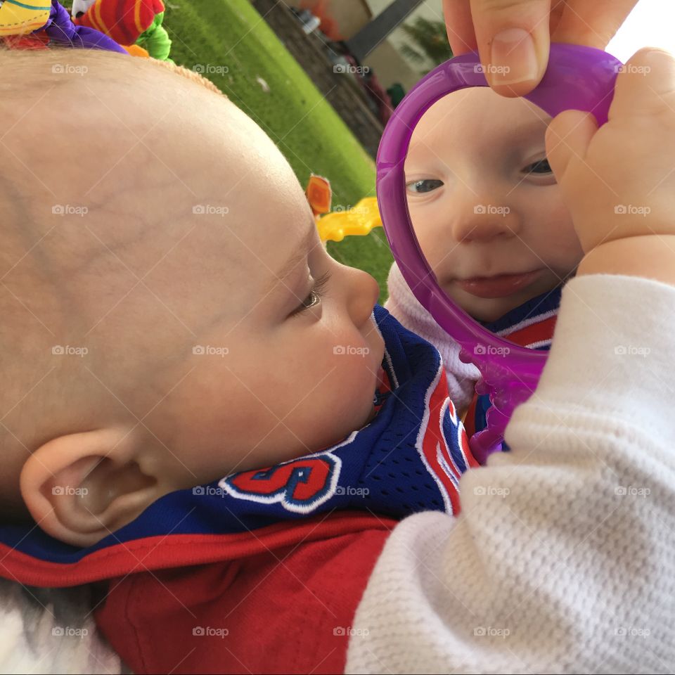 Baby holding mirror